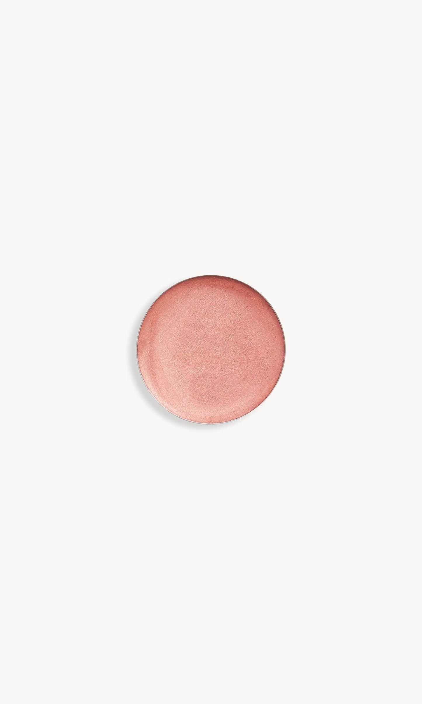 Circle of iridescent rose gold cream eye shadow on white background